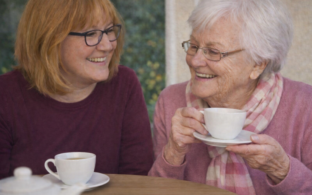 service user Margaret enjoying a cup of tea in the garden with Sarah